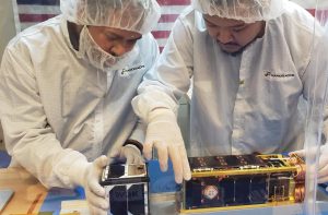 two students working on the swampsat II satellite